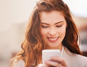 smiling woman looking at phone