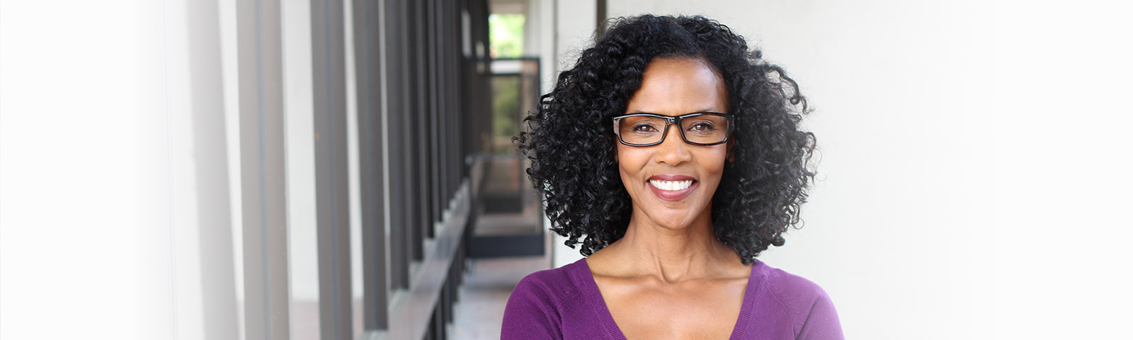 black woman with glasses smiling