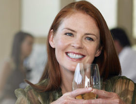 smiling woman drinking a glass of wine