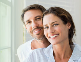 happy couple smiling on a green background