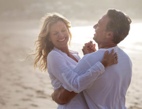 A happy couple on the beach laughing