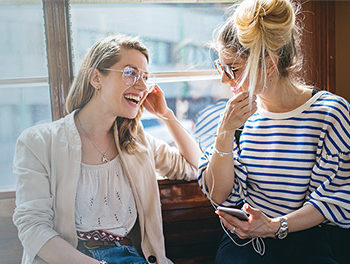 smiling lesbian couple listening to music