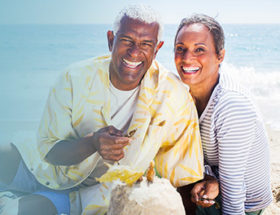 black couple laughing at the beach