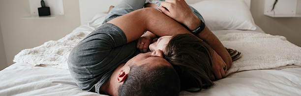 Couple lying in bed hugging