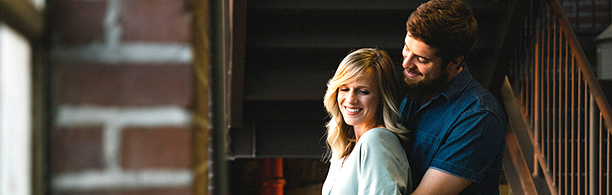 couple hugging behind by window