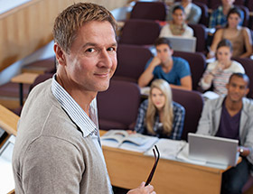 academic looking at camera with students behind