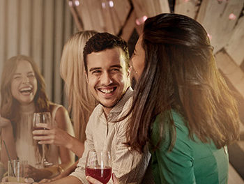 man chatting up an attractive woman in a bar