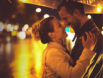 couple embracing in the rain under an umbrella