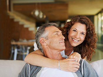 mature couple on sofa smiling