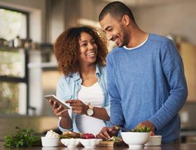 vegan couple in the kitchen cooking and smiling