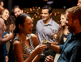 couple smiling at bar toasting