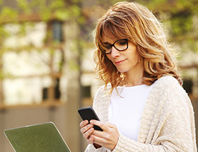 woman in glasses using smart phone