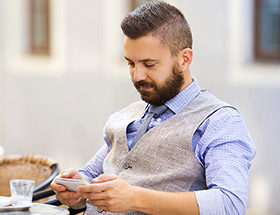 exclusive man looking at smart phone at cafe