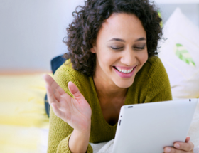 curly haired Australian woman sending online dating messages from her tablet