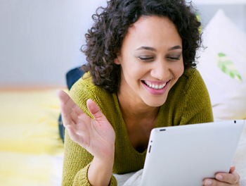 curly haired Australian woman sending online dating messages from her tablet