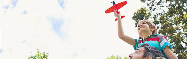 father and son play with toy plane