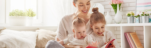 woman reading with two young children