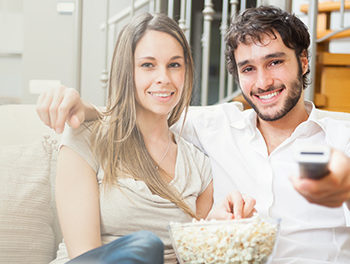 Happy couple watching television