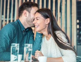 Man making a woman laugh over water